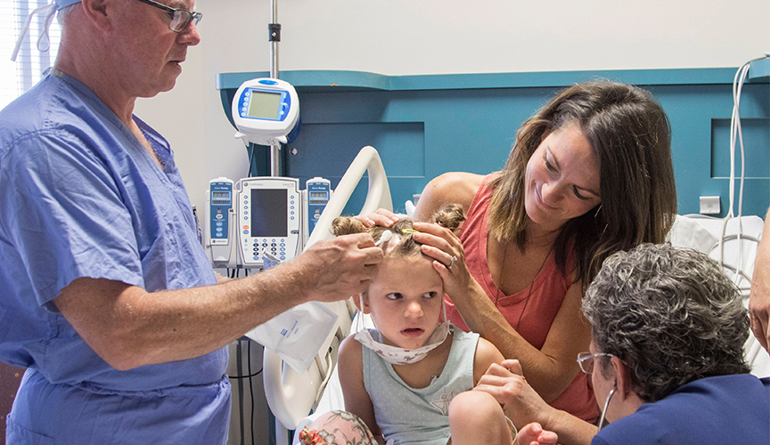 Le Bonheur physician examing patient with Batten Disease